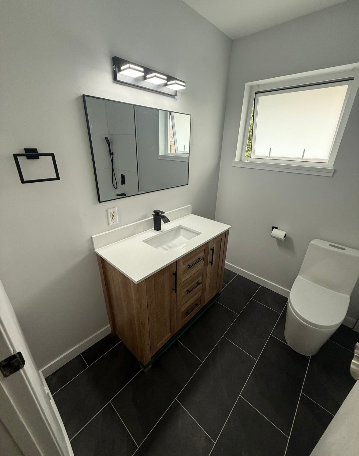 Finished bathroom with wood vanity and black fittings